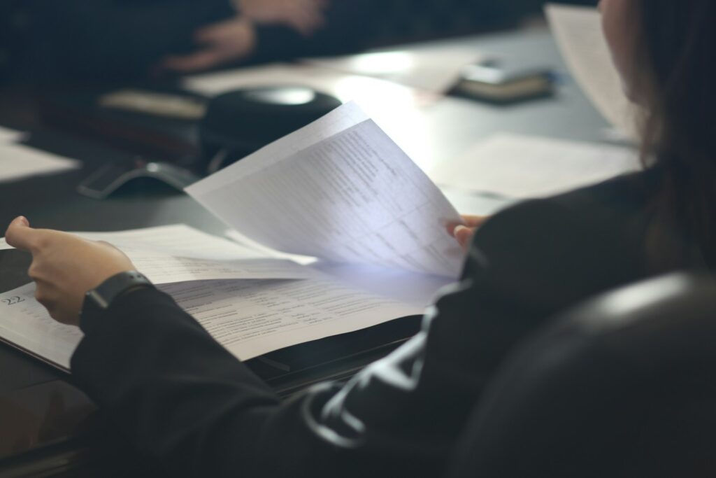 Woman sitting at a table reading a paper