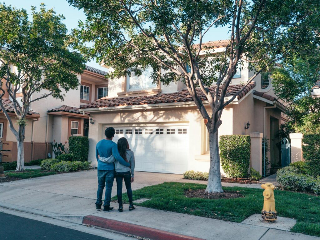 Couple standing in front of their new house