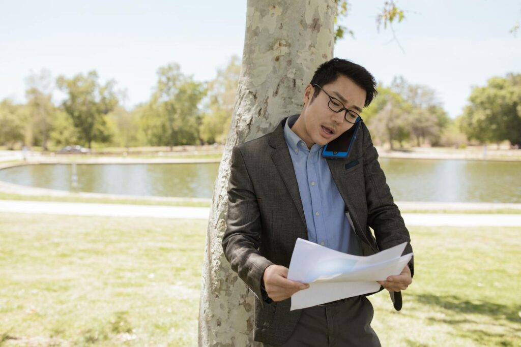 Man talking on a phone while looking through divorce papers