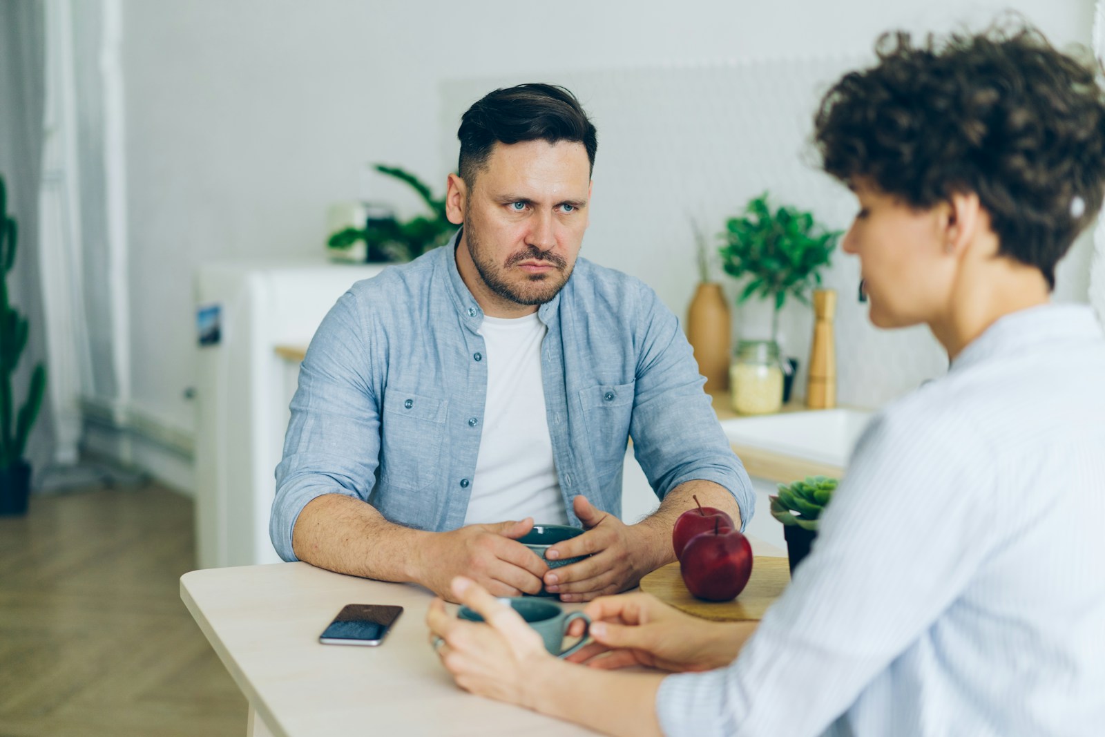 Man sitting at a table talking to woman